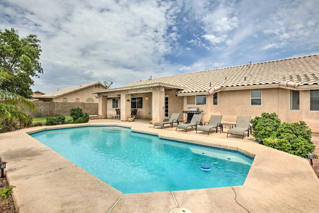 a swimming pool in front of a house at Sunny Yuma Retreat with Private Pool and Grill! in Yuma