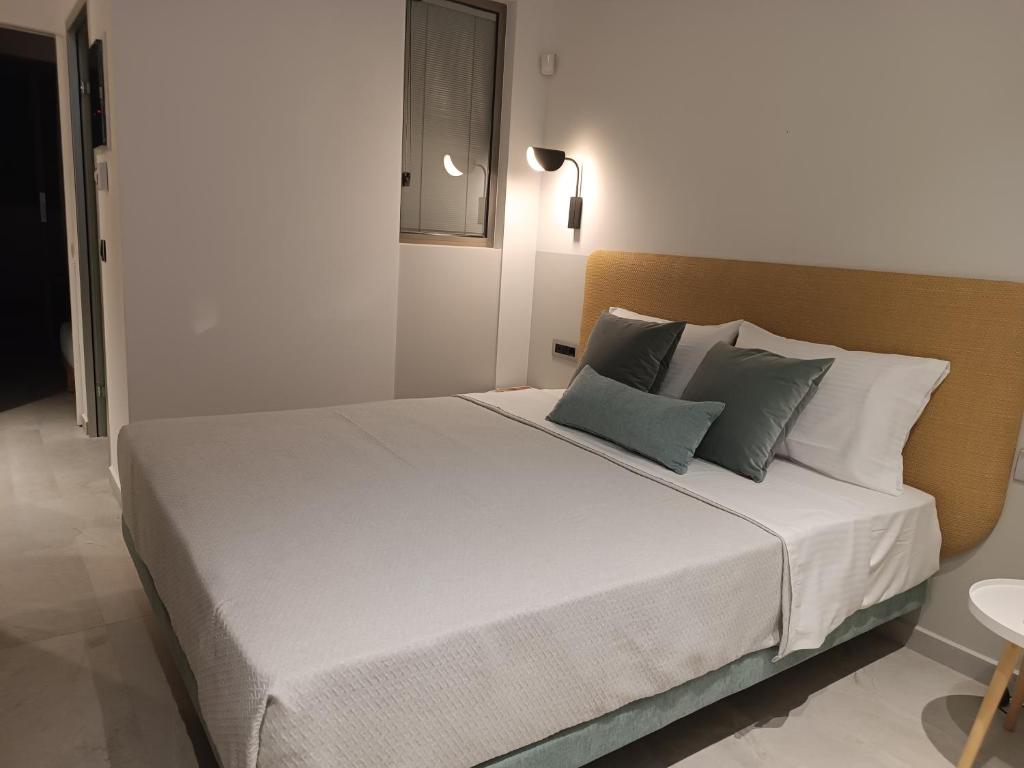 a bedroom with a large white bed with blue pillows at MERA APARTMENTS in Stavros