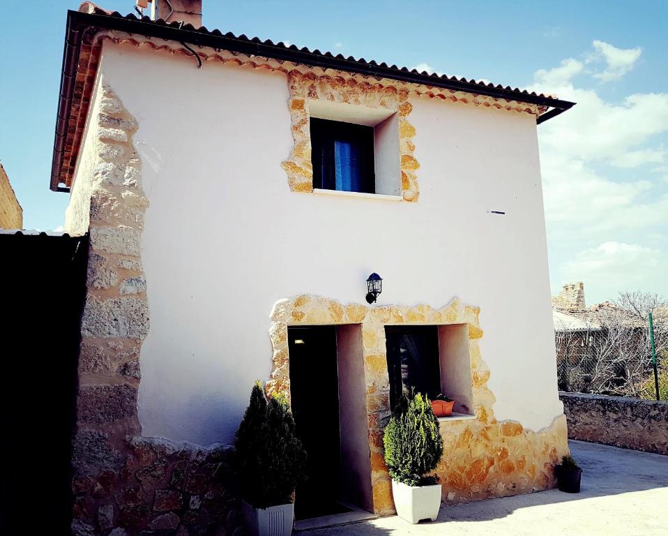 un edificio blanco con dos macetas delante de él en Casa Rural Río Duratón, 