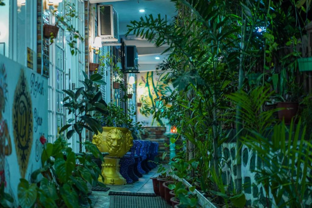 ペラデニヤにあるDELIGHT REICH HOTELのたくさんの植物と黄花瓶が咲き誇る部屋