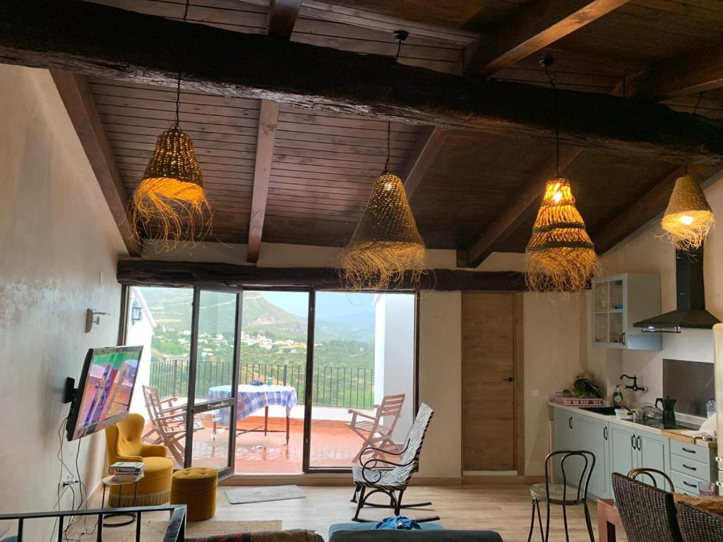 a room with chairs and pendant lights and a kitchen at Ático El Más allá in Chulilla