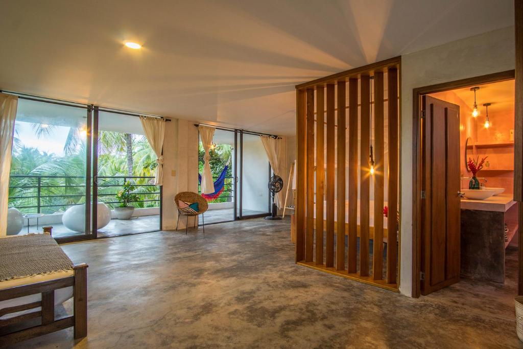 a living room with glass doors and a room at Casa Chapolin Boutique Guesthouse in Palomino