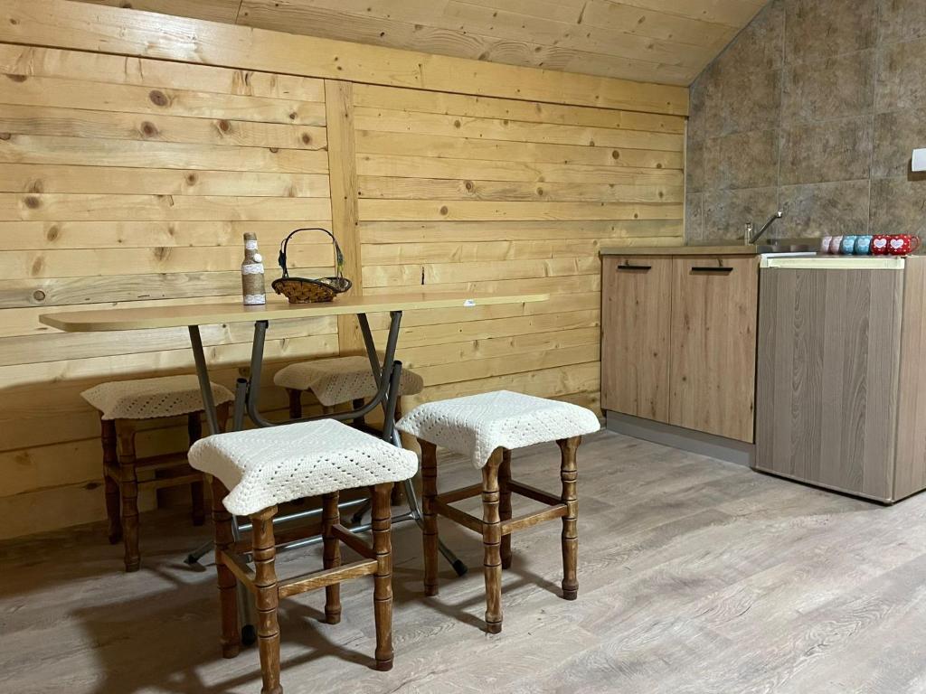 a kitchen with a table and chairs and a refrigerator at Brvnara Krin 1 in Nova Varoš