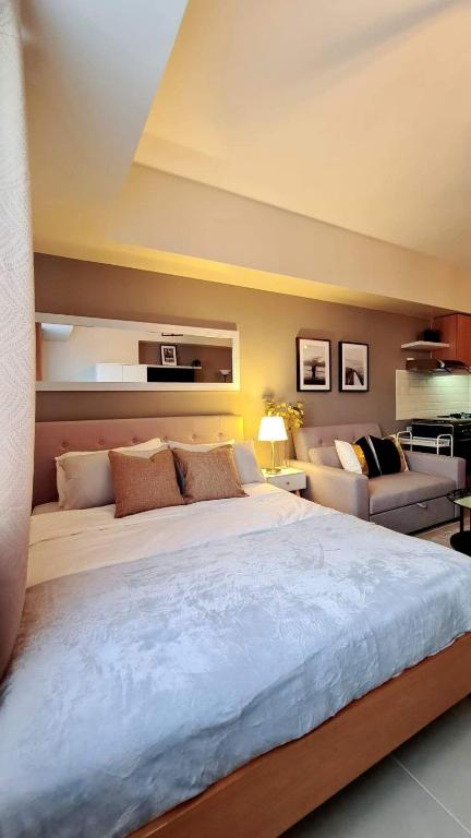 a bedroom with a large bed and a couch at The Nook at Serin Tagaytay in Tagaytay