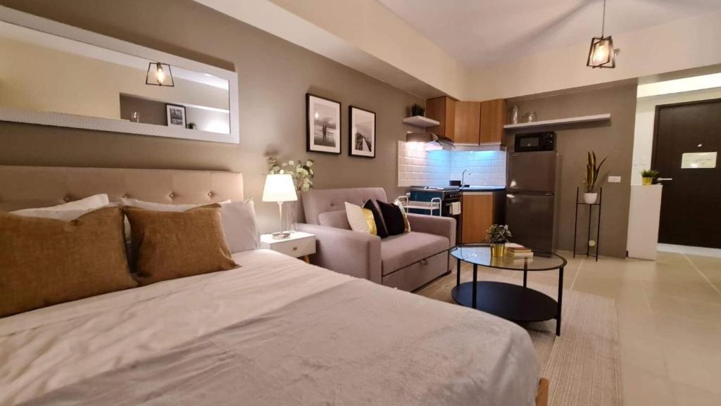 a bedroom with a bed and a living room at The Nook at Serin Tagaytay in Tagaytay