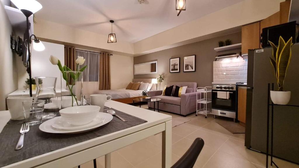 a kitchen and living room with a table and a couch at The Nook at Serin Tagaytay in Tagaytay
