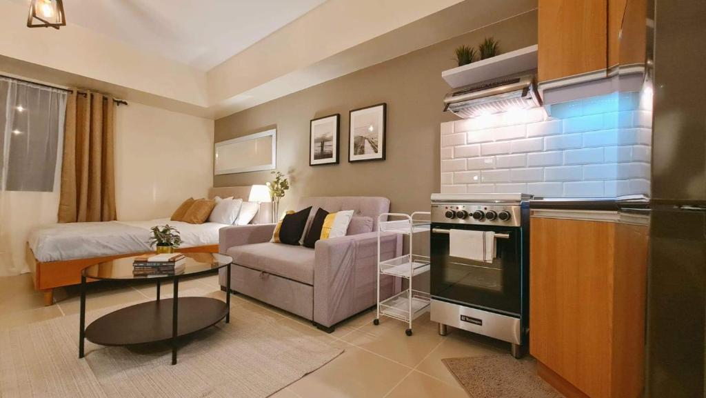 a living room with a couch and a bed and a kitchen at The Nook at Serin Tagaytay in Tagaytay