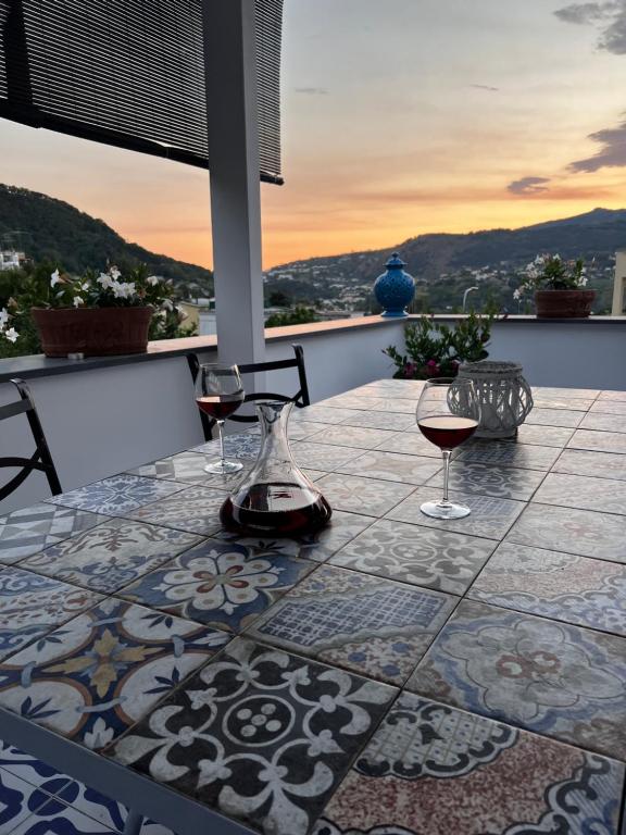 einen Tisch mit einem Glas Wein auf der Terrasse in der Unterkunft Villa Rosa in Ischia