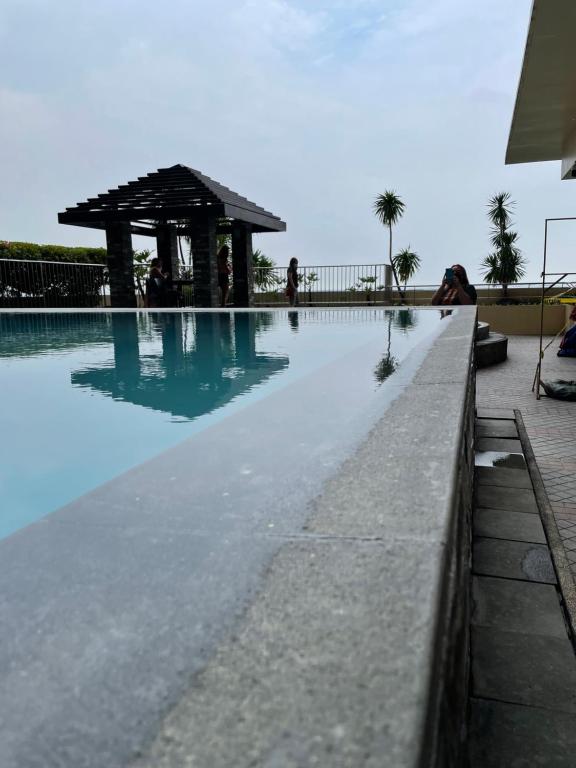 a swimming pool with a pavilion in the middle of it at Grand Riviera Suites Comfy Condo near US Embassy Manila Bay Roxas Blvd Ermita Manila in Manila