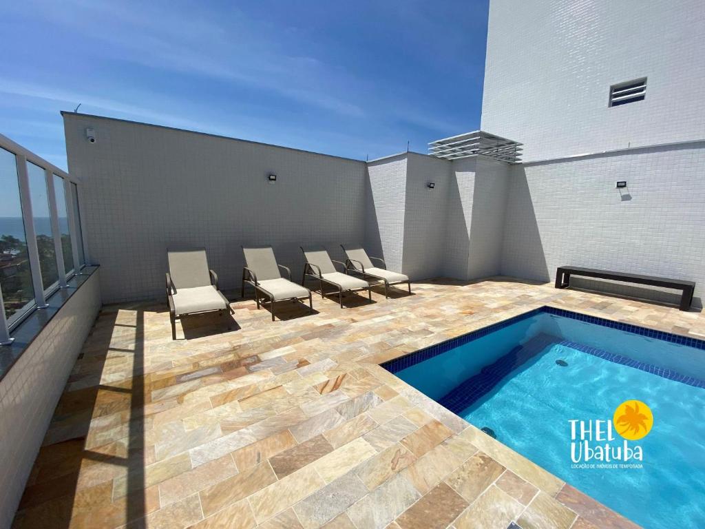 a balcony with a swimming pool on the roof of a building at Top das Toninhas – Apto c/ Ar e Vista Mar e roupa de cama in Ubatuba