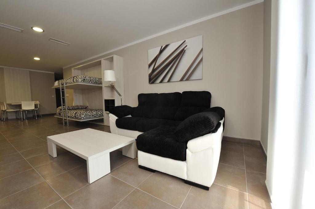 a living room with a couch and a table at Aparthotel Meseguer in Alcañiz