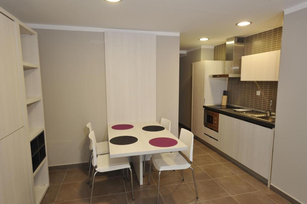 a small kitchen with a table and chairs at Aparthotel Meseguer in Alcañiz