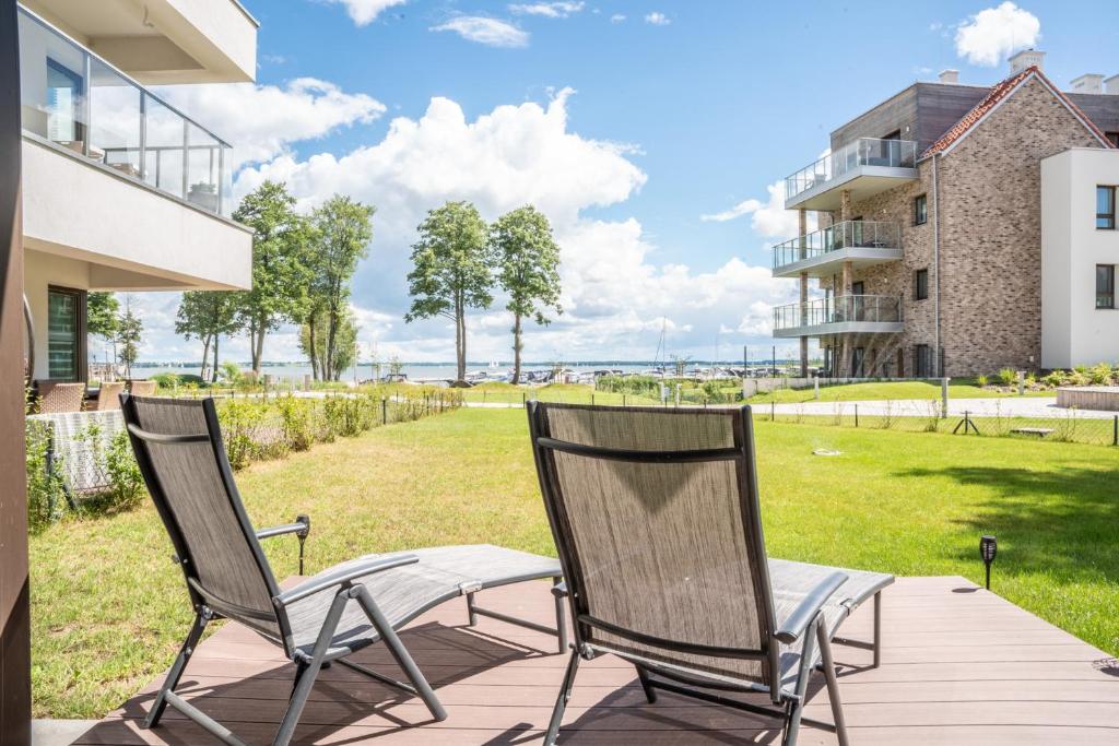 2 sillas en una terraza con vistas a un patio en Nautica 5 en Giżycko