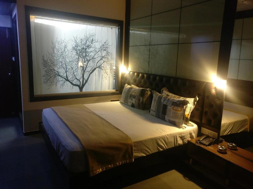 sypialnia z dużym łóżkiem i oknem w obiekcie Hotel KK Residency w mieście Nagpur