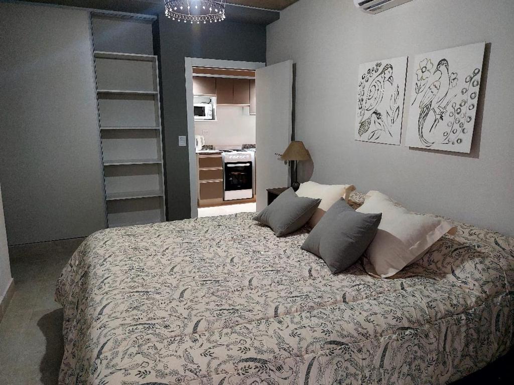 Un dormitorio con una cama grande con almohadas. en MIRACERROS Departamento en Salta en Salta