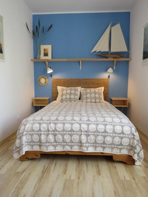 a bedroom with a large bed and a blue wall at garncarska6 in Gdańsk