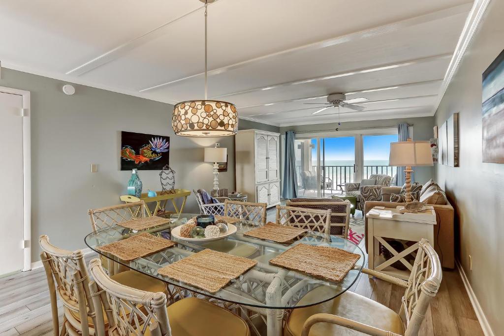a dining room and living room with a table and chairs at Unobstructed Oceanfront View-Direct Beach Access-Oceanfront Pool-Amelia South L4 in Fernandina Beach