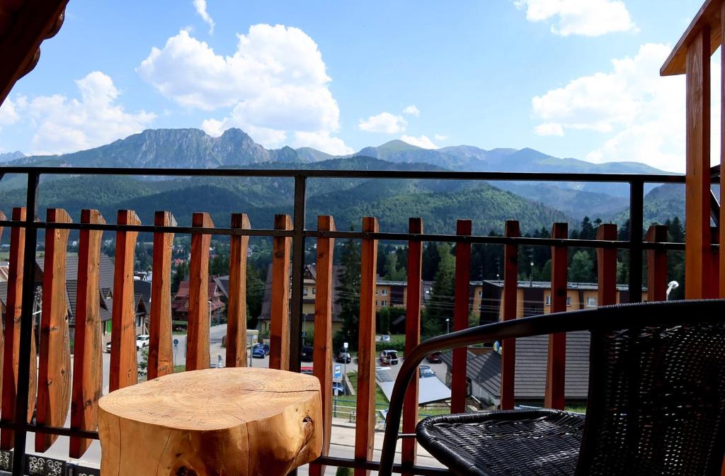 a table and chair on a balcony with a view of mountains at willa U Laskowych in Kościelisko