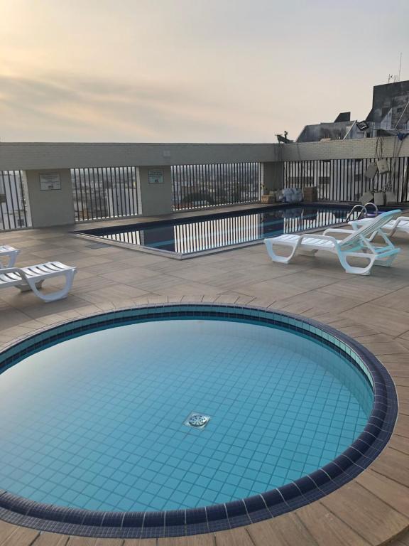 una gran piscina en un balcón con 2 sillas en Palladium Apart Service en São Vicente
