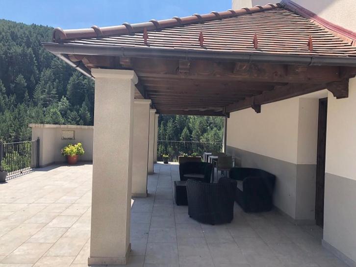 een paviljoen met een tafel en stoelen op een patio bij Casa Aurita in Ansó
