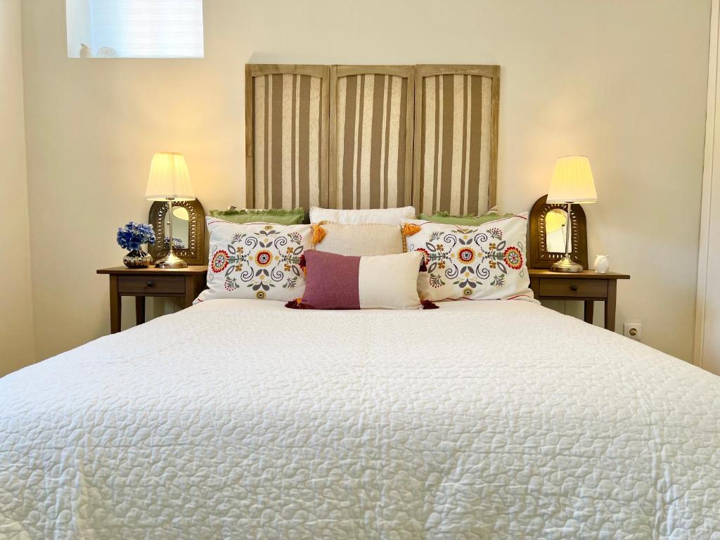ein Schlafzimmer mit einem großen weißen Bett mit zwei Lampen in der Unterkunft Fleur de Lis in Belas