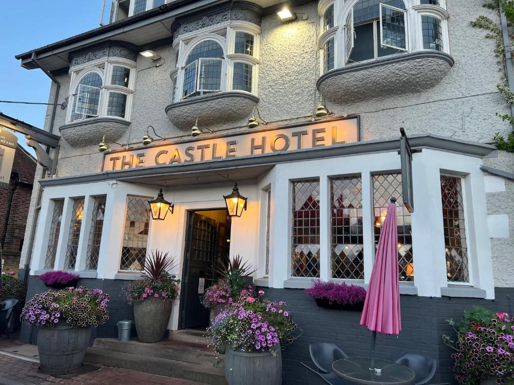 un hôtel-château avec un parasol rose devant lui dans l'établissement Castle Hotel, à Eynsford