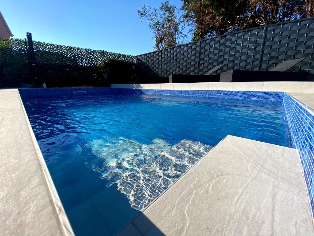a swimming pool with blue water in a backyard at Villa Danza Del Mar - Designed for Adults in Vir
