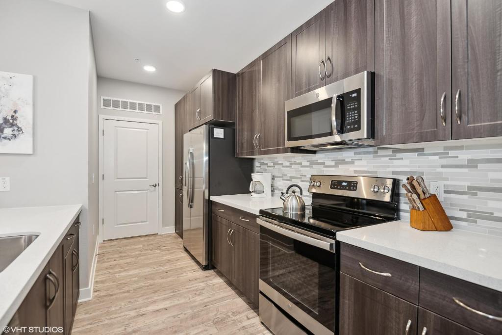 a kitchen with stainless steel appliances and wooden cabinets at LUX 2 BED DESERT RIDGE 2 HEATED POOLS GYM in Phoenix