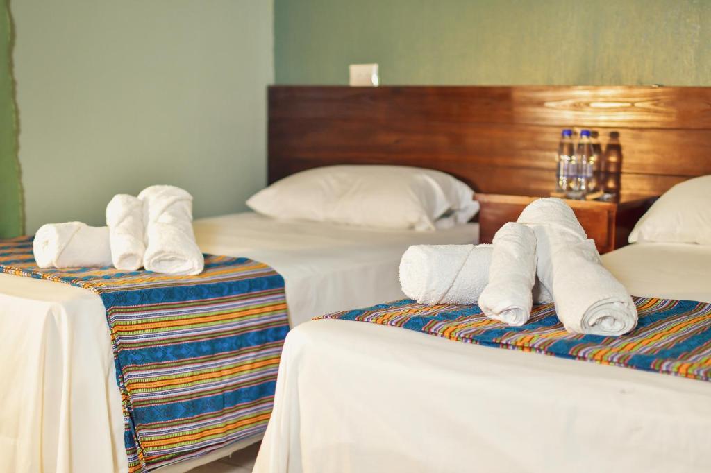 ein Zimmer mit 3 Betten und Handtüchern darauf in der Unterkunft POSADA SAN FRANCISCO 