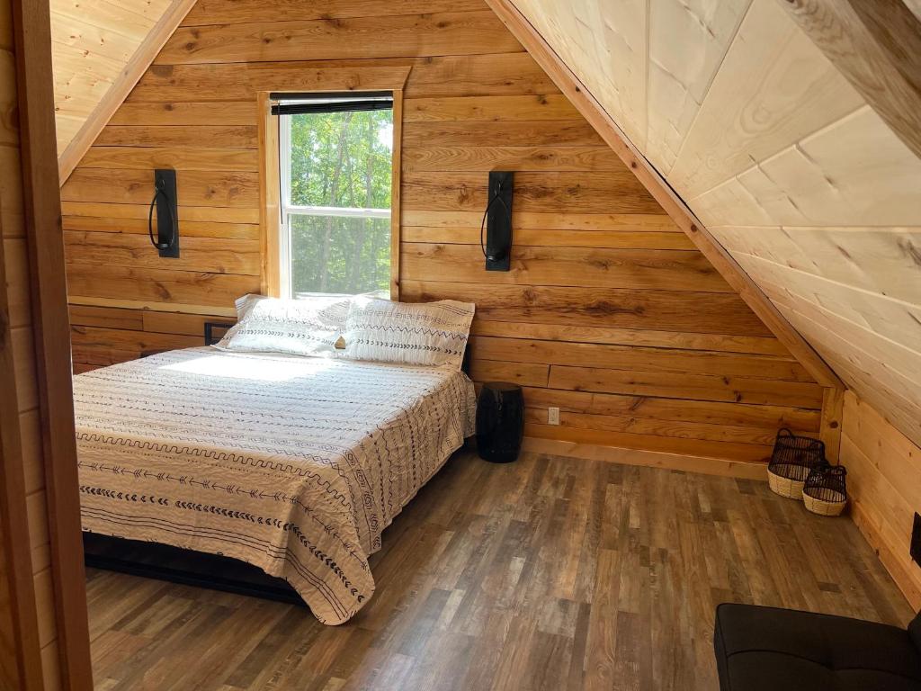 een slaapkamer in een blokhut met een bed bij windrock ridge - Ethan in Oak Ridge