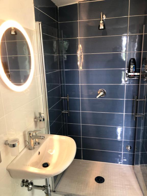 ein blau gefliestes Bad mit einem Waschbecken und einem Spiegel in der Unterkunft B&B La Marinella in Palinuro