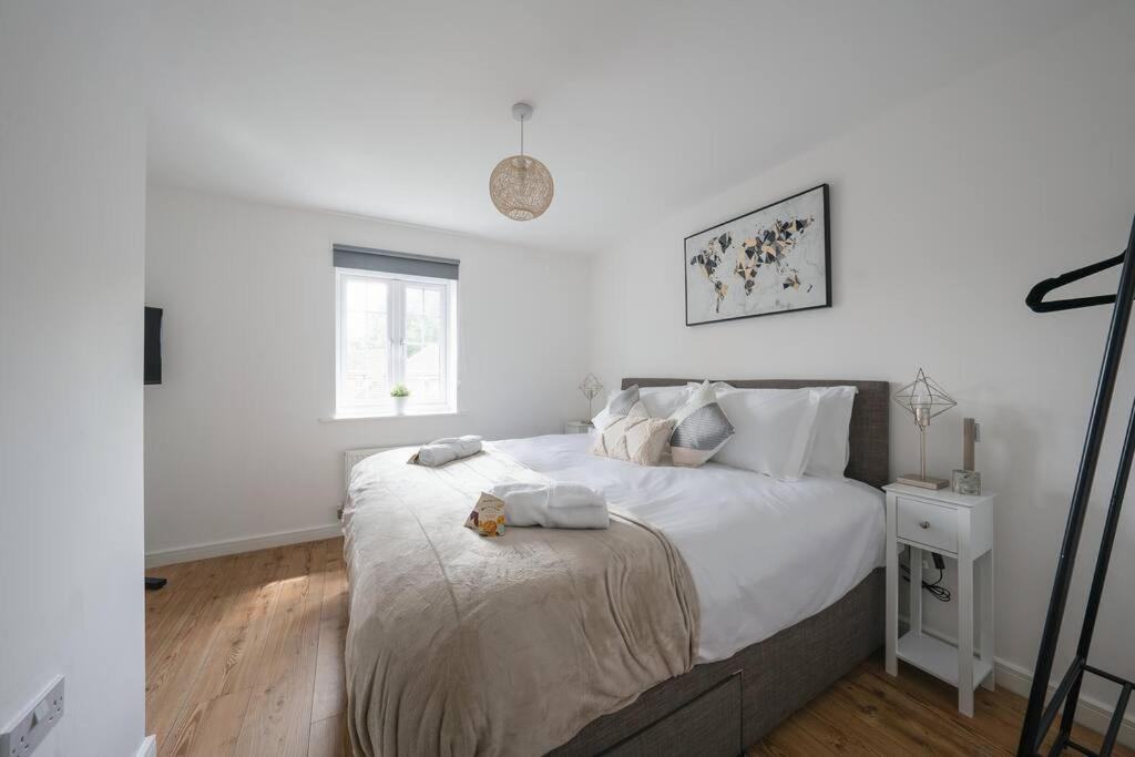 a white bedroom with a large bed with white pillows at Stylish 2-bed home - For Company contractor and Leisure stays - NEC, Airport, HS2, Contractors, Resort World in Birmingham