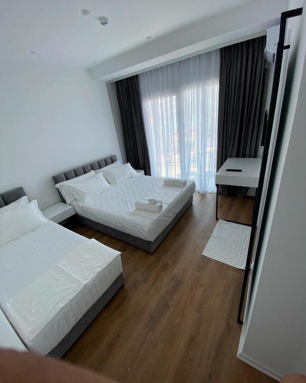 a bedroom with two beds and a desk and a mirror at SEA & LAKE VIEW VILLA in (( Kalive Gjoka ))