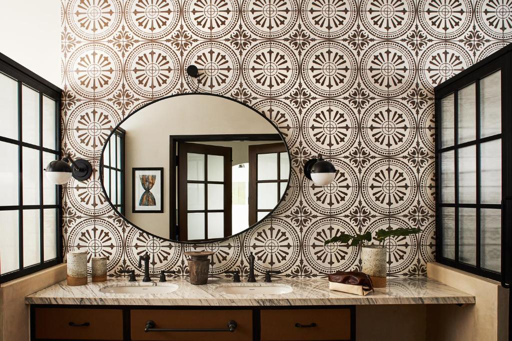 a bathroom with a large mirror on a wall at Hotel Figueroa, Unbound Collection by Hyatt in Los Angeles