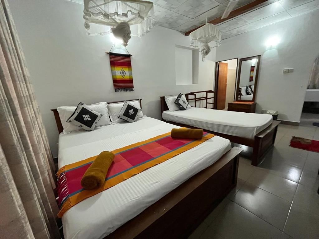 two beds in a room with two beds sidx sidx sidx at Crystal Lake Resort in Kandy