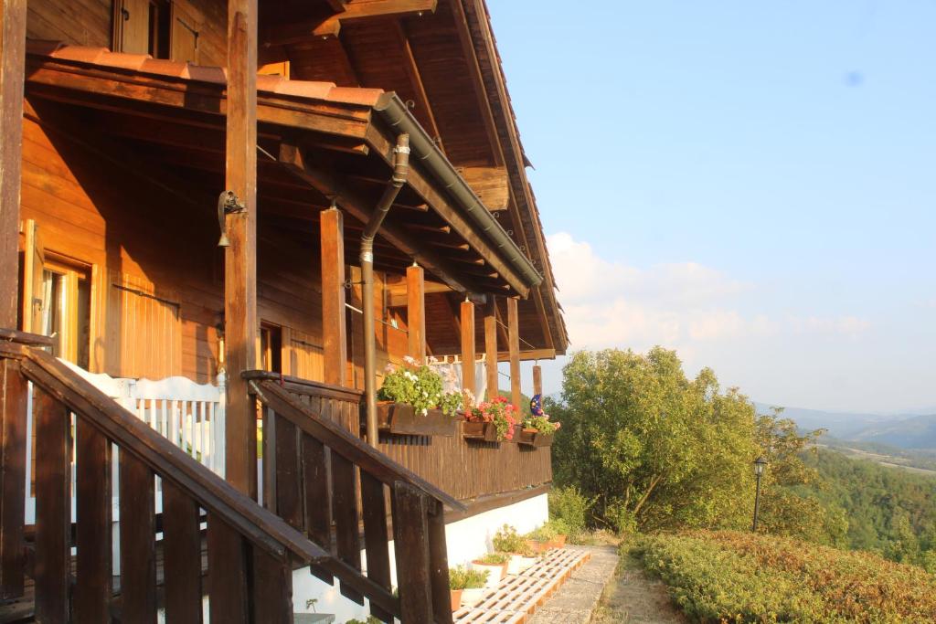 a wooden house with a balcony with flowers on it at Bed and Breakfast La Casa del Sole in Momperone