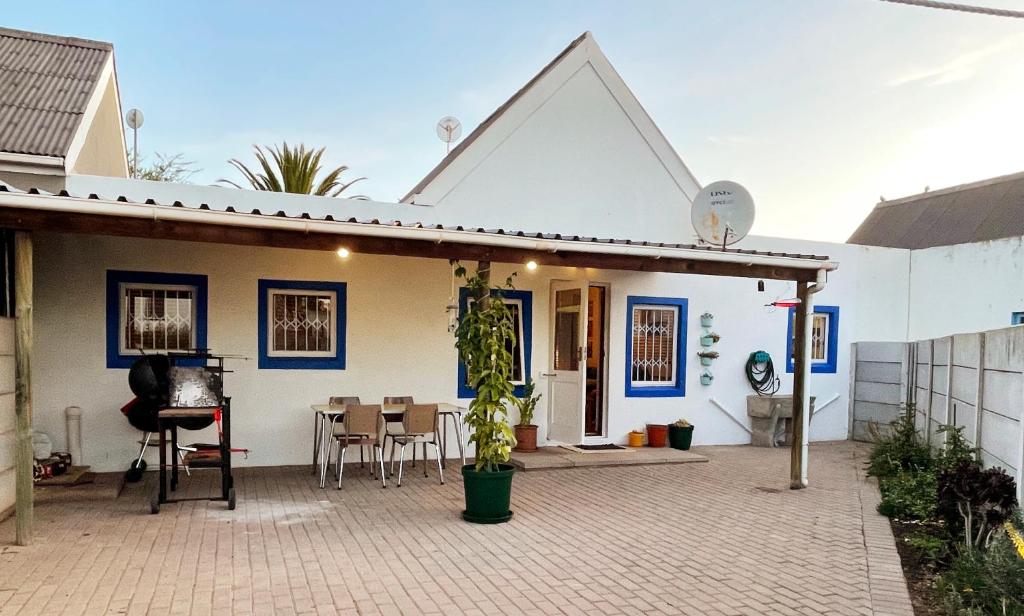 a white house with a patio and a table at Self Catering Saldanha House in Saldanha