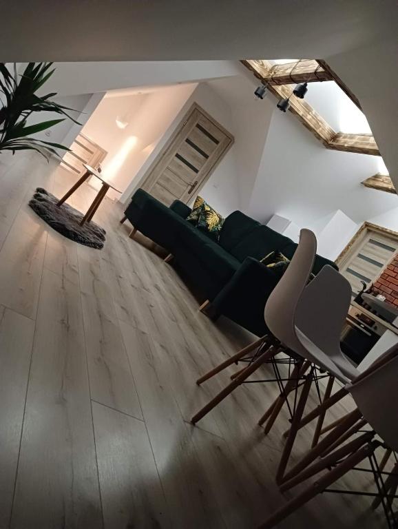 a living room with a green couch and chairs at Apartament Nasze Poddasze in Ciche