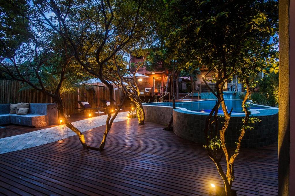 a deck with lights and a swimming pool at night at Pousada Alecrim do Campo in Sao Jorge