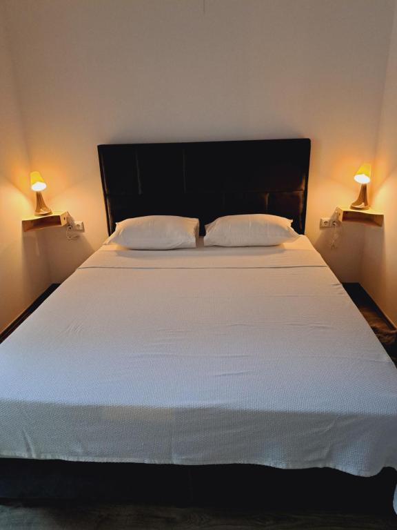 Apartman Megolina في فاراجدين: سرير أبيض كبير مع وسادتين ومصباحين