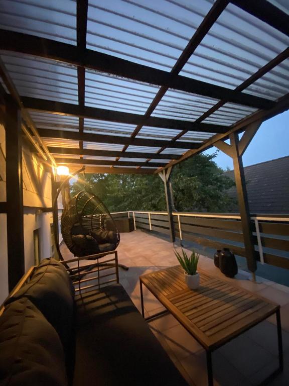 a patio with a couch and a table on a deck at Ferienhaus International in Bad Harzburg