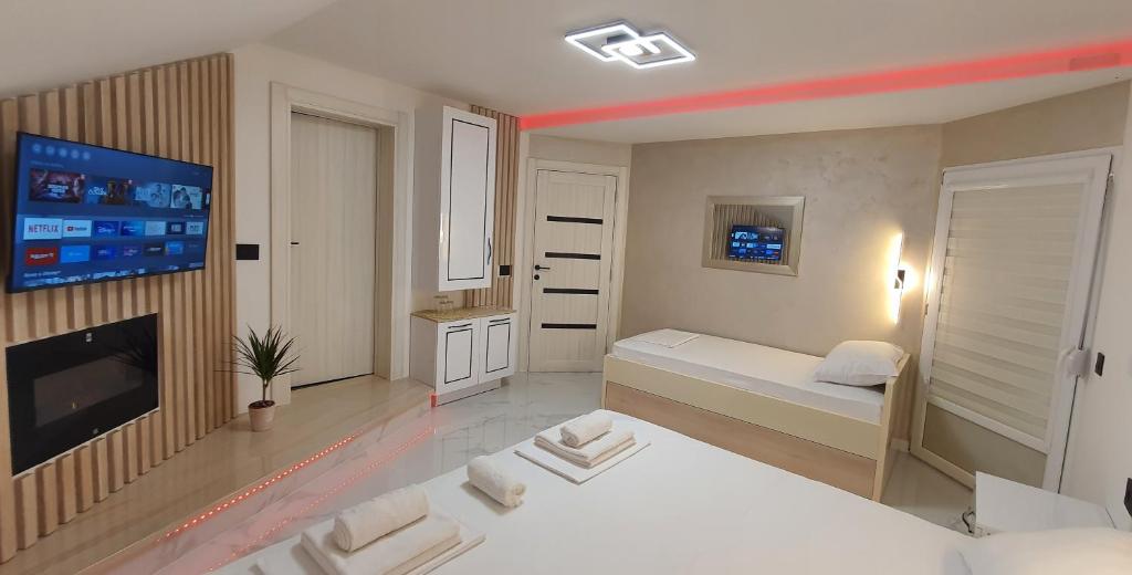 a bedroom with two beds and a flat screen tv at Pansion Eden in Niš