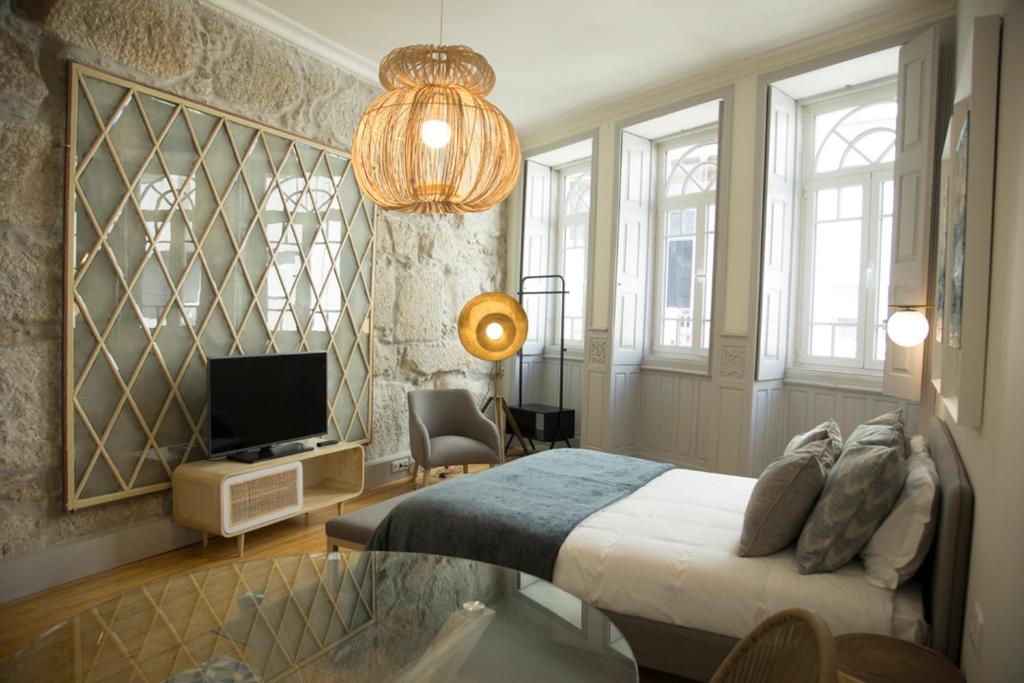 a bedroom with a bed and a television and a chandelier at TOP Porto in Porto
