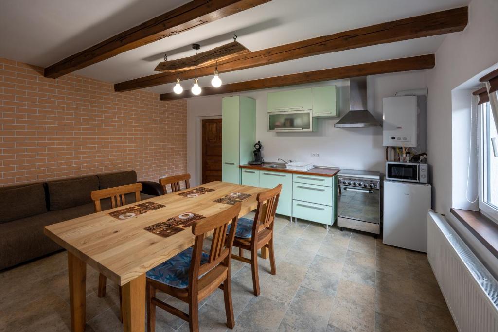 a kitchen and dining room with a wooden table and chairs at Casa Rustik Danes in Daneş