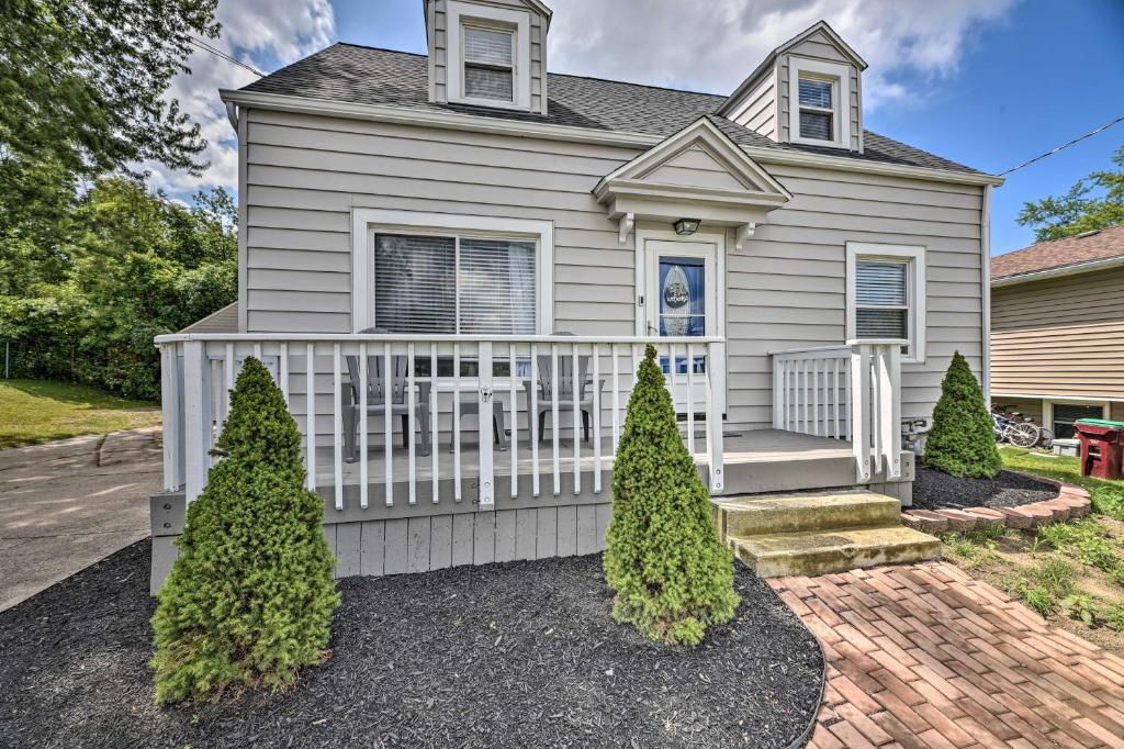 a house with a white fence and two trees at Orchard Park Home Less Than 2 Mi to Highmark Stadium! in Orchard Park
