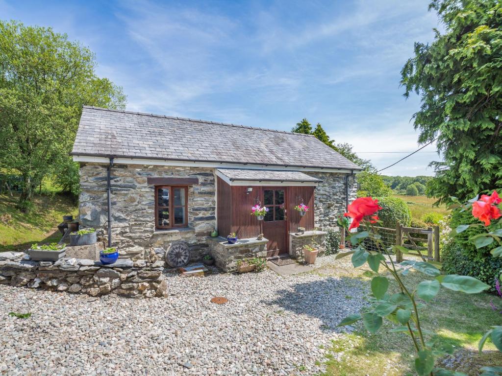 a small stone cottage in a garden at Bwythyn Y Wennol in Beddgelert