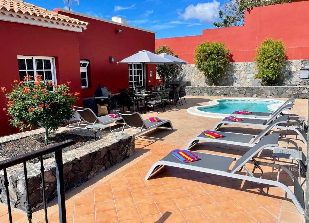 a patio with lounge chairs and a swimming pool at Villa Consuelo - Quiet Location Close to Resorts in Buzanada