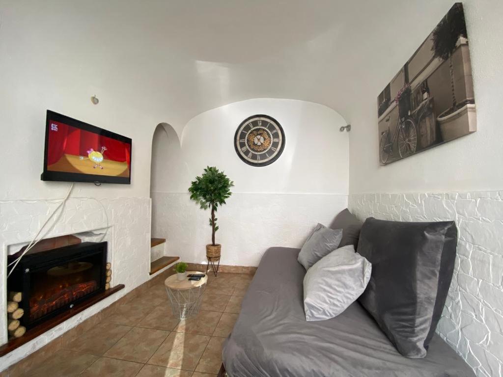 ein Wohnzimmer mit Couch und Kamin in der Unterkunft Évora Romana Alojamentos T2 Aqueduto in Évora