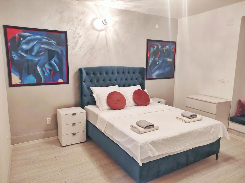 sypialnia z łóżkiem z czerwonymi poduszkami w obiekcie Apartments Golden Bridge w mieście Mostar