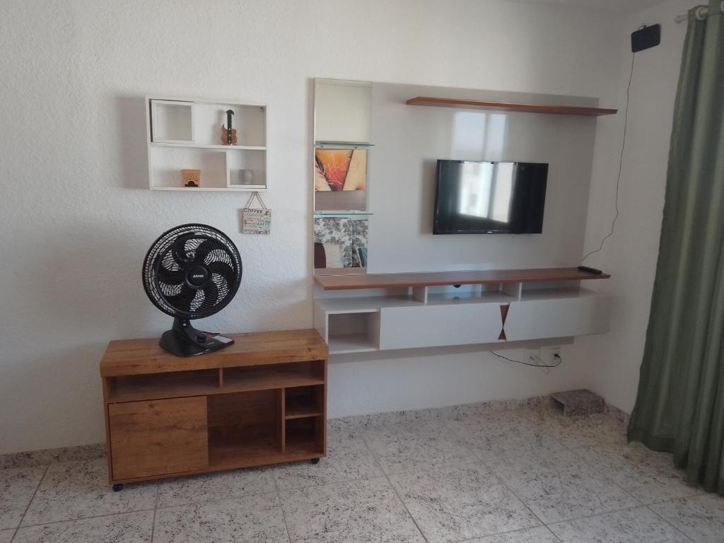sala de estar con TV y mesa de madera en Apartamento inteiro próximo aeroporto de Confins, en Vespasiano